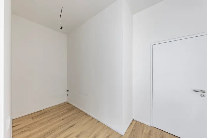 Prostor s přípravou rozvodů. Kuchyňská linka ani spotřebiče nejsou instalovány.